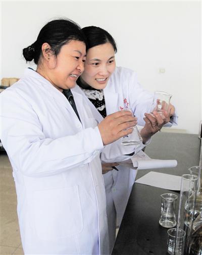 科技站农业技术员张晓云(左一)与助手在实验室做测土配方实验。