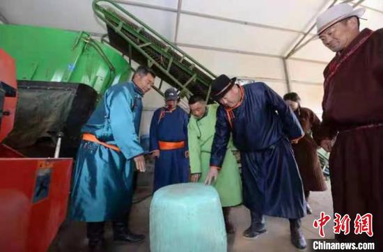 图为阿佈日米德(左一)为上门提问的牧民答疑。 齐波 摄