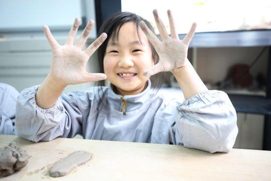 图为同学们正在制作陶艺草鞋。