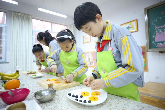 图为同学们正在制作水果拼盘。