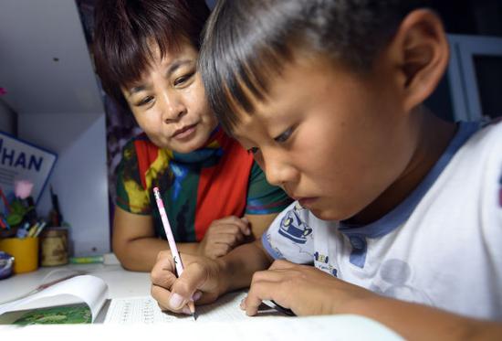 9月10日,李珺在輔導王輔正寫作業。