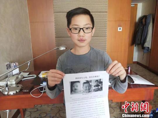 图为王龙川拿着寻人启事。 张林虎 摄