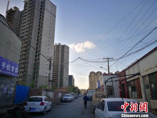 图为沙尘暴背景下,行色匆匆的市民。 李爱平 摄