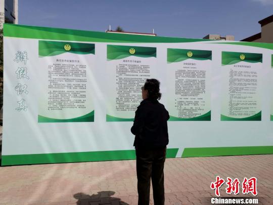 图为老年民众观看宣传展板。 乌娅娜 摄