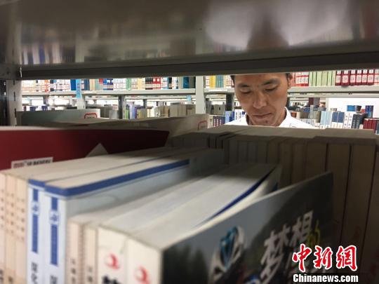 图为白灵光在图书馆看书。 张玮 摄