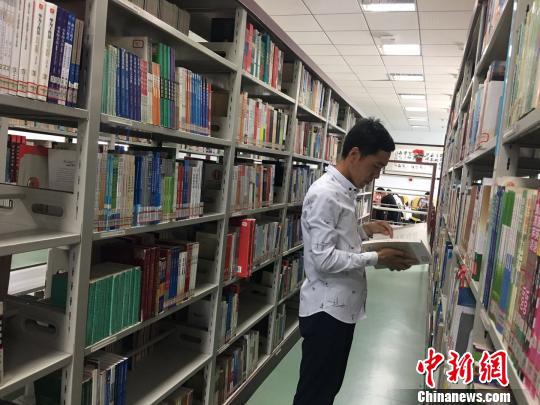 图为白灵光在图书馆看书。 张玮 摄
