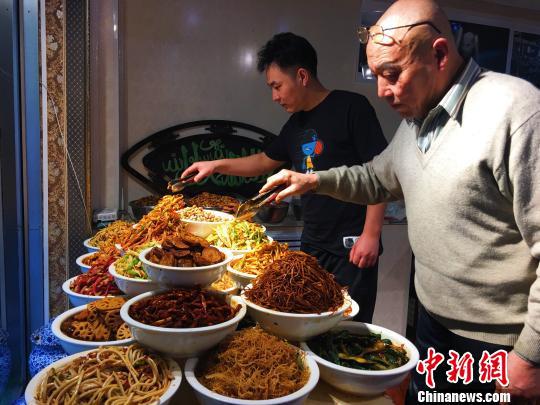 图为张龙父子共同研究“菜品”。 张玮 摄