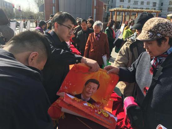 ↑工作人员为群众发放安全宣传挂历