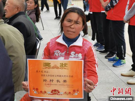 杨长秀替丈夫领到的“好村长奖。” 李爱平 摄