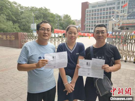 图为刘东(左)和女儿以及刘文忠考试后合影。 张林虎 摄