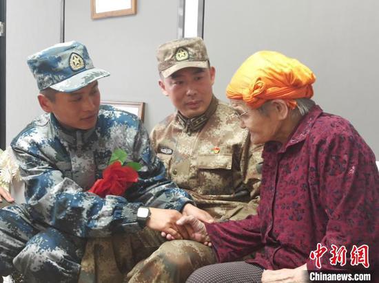 图为都贵玛老人与加那拉着手聊天。 党沛强 摄