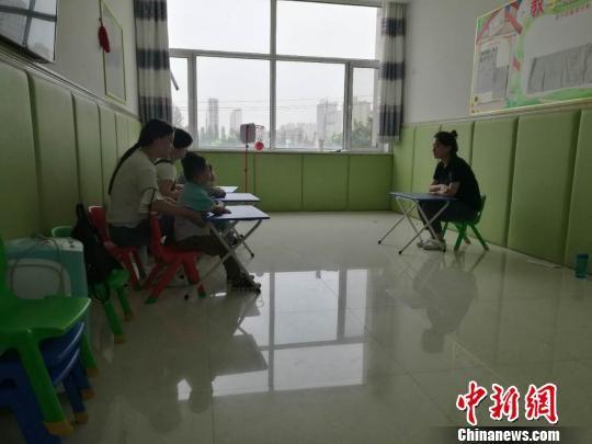 图为康复中心的家长在听课做笔记。 张林虎 摄