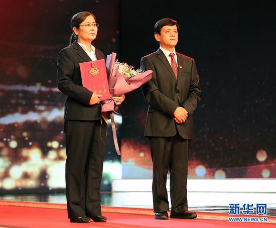 内蒙古自治区党委常委、自治区纪委书记、监委主任刘奇凡(右)为江来柱家人颁发北疆楷模荣誉证书和奖章。新华网 石毅 摄