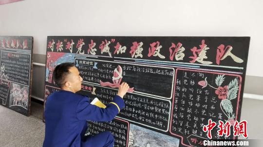 图为彝族小伙布依小兵书写板报。 张林虎 摄