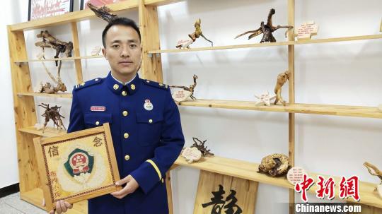 图为布约小兵展示手工艺品。 张林虎 摄
