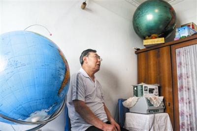 68岁的包广田与两个手绘地球仪。