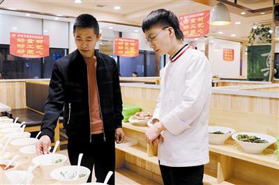 李才(左一)指导员工。