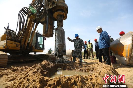 图为旋挖机钻孔打基础。 兰宁 摄