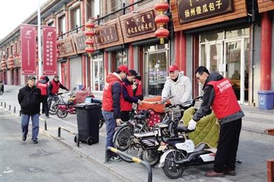 志愿者在街道上摆放自行车。