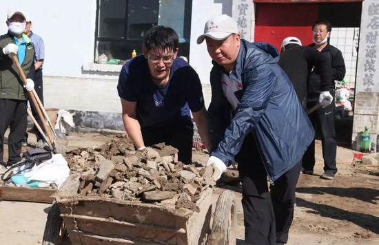 史万钧帮助受灾村民收拾院落。
