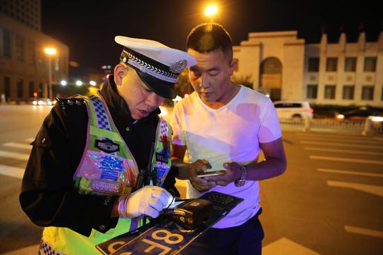 民警正在用警务通查询涉牌涉证违法行为(韩斌)