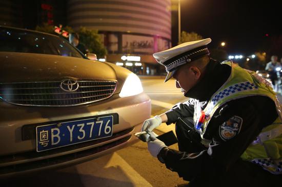 民警认真核对牌照真伪(韩斌)