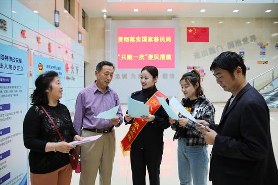 呼和浩特出入境民警向前来办证的群众介绍办证流程。
