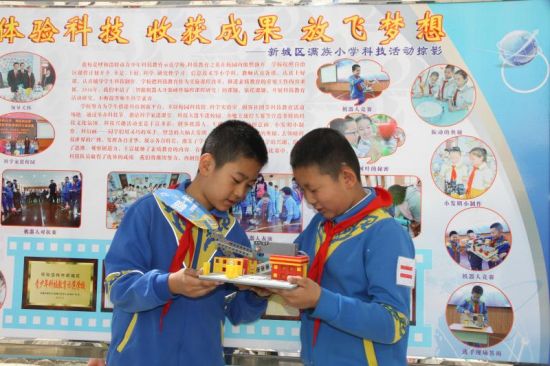 满族小学学生正在展示他们制作的“风扇”