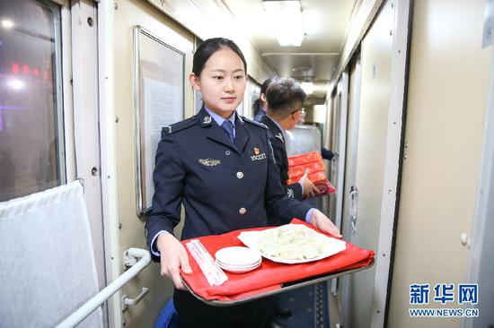 边检民警为归国旅客送上热腾腾的饺子。新华网发(郭鹏杰摄)