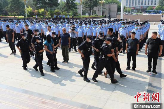 图为两名犯罪嫌疑人被押解回呼和浩特。 杨超 摄