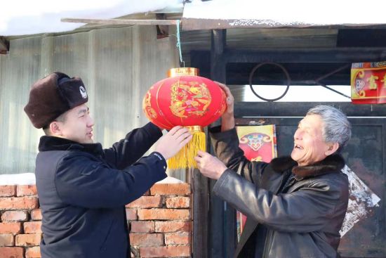 图为:派出所民警为老人挂灯笼