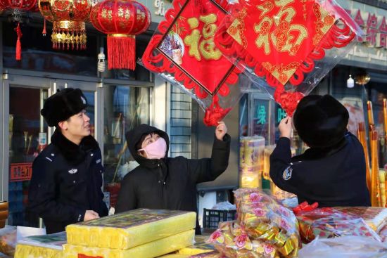 图为:派出所民警为辖区群众购买福字。