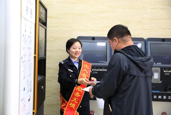 民警协助群众在自助取证机上领取证件1