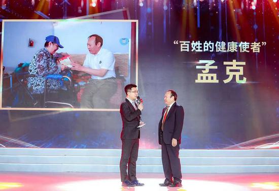 孟克(右)获评“中国网事·感动2019”年度人物。新华网发