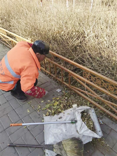 环卫工人清理绿化带里的杂物