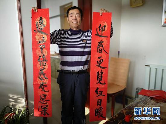 温艮忠展示春联。(新华网 杨腾格尔摄)