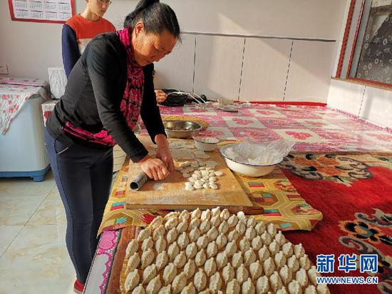 温艮忠的爱人正在包饺子。(新华网 杨腾格尔摄)
