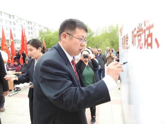 图为与会人员在签名板上签名。