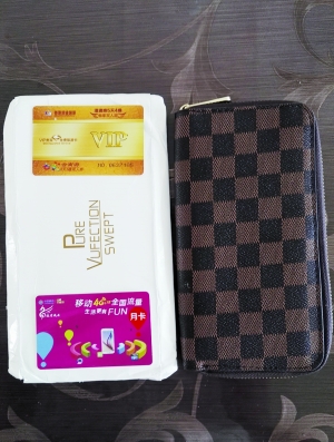 郭先生收到的山寨LV手包和两张卡( 摄影/本报记者 查 娜)