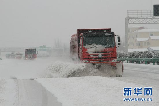 除雪车在高速公路上实施不间断除雪作业(罗杰 摄)