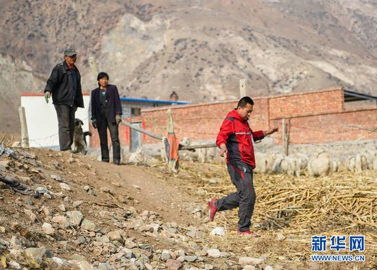 赵飞在土默特左旗向村民们打听完道路情况返回车上