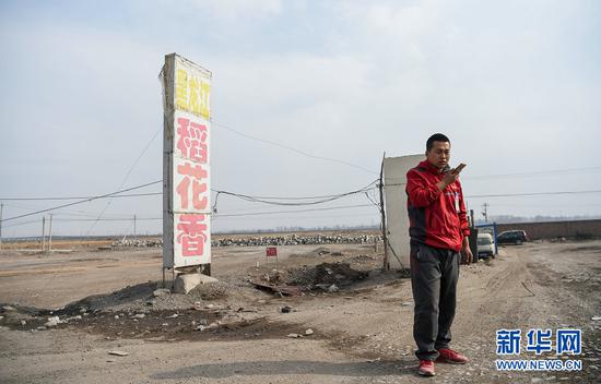 赵飞在土默特左旗一条公路旁等待客户来取包裹