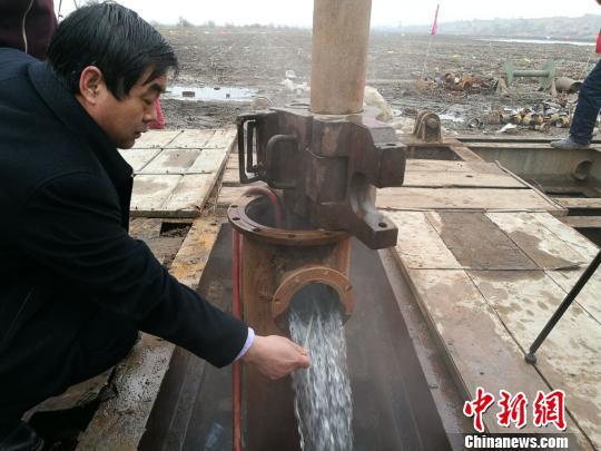 图为内蒙古托克托县打出地热井,工作人员测量水温。 李爱平 摄