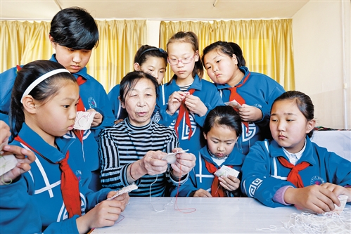 指导奥日雅玛拉刺绣社团的小学生学习刺绣。