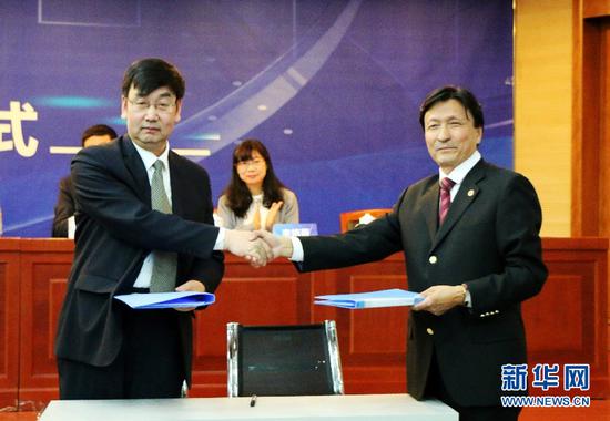 内蒙古大学文学与新闻传播学院副院长魏永贵(左)与新华社中国经济信息社内蒙古中心总经理、经济研究中心主任张润光签署战略合作协议