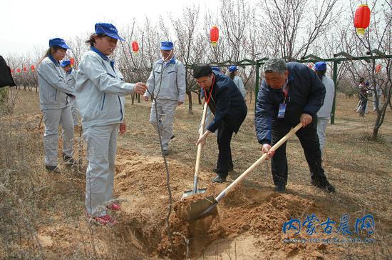 出席开幕式的嘉宾与当地种植基地工作人员共同种幸福树,祈幸福年