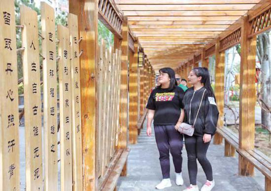 社会主义核心价值观主题园长廊内,挂满了传统文化标语牌,吸引了不少市民观看。