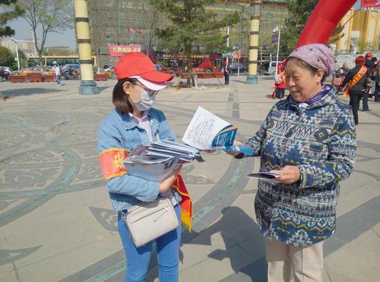 安全生产志愿者向市民发放宣传材料,讲解相关安全知识。