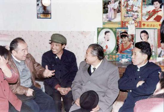 1991 年2 月,布赫同志(左一)与原海勃湾矿务局职工梁俊清一家亲切交谈。(神华乌海能源公司提供)