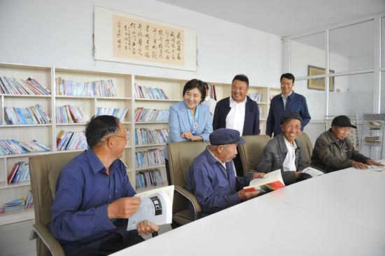 自治区党委副书记、自治区主席布小林在乌兰察布市化德县德包图乡互助幸福院和老人们交流。韩卿立 摄